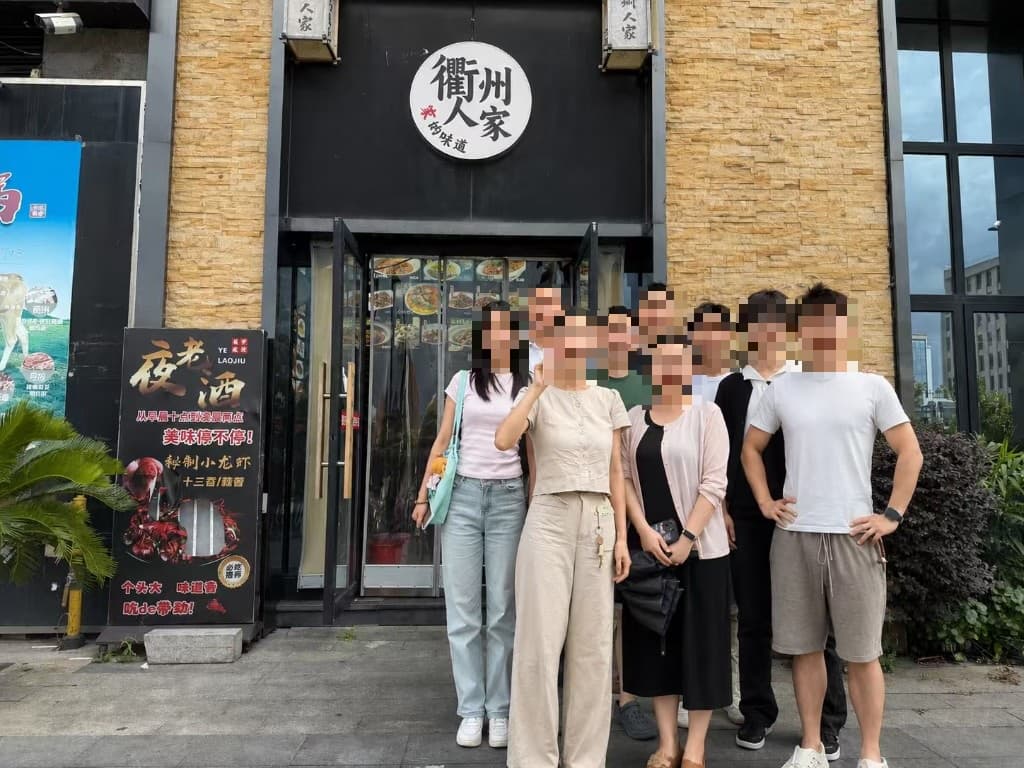 The Hangzhou R&D team outside a restaurant, faces pixelated