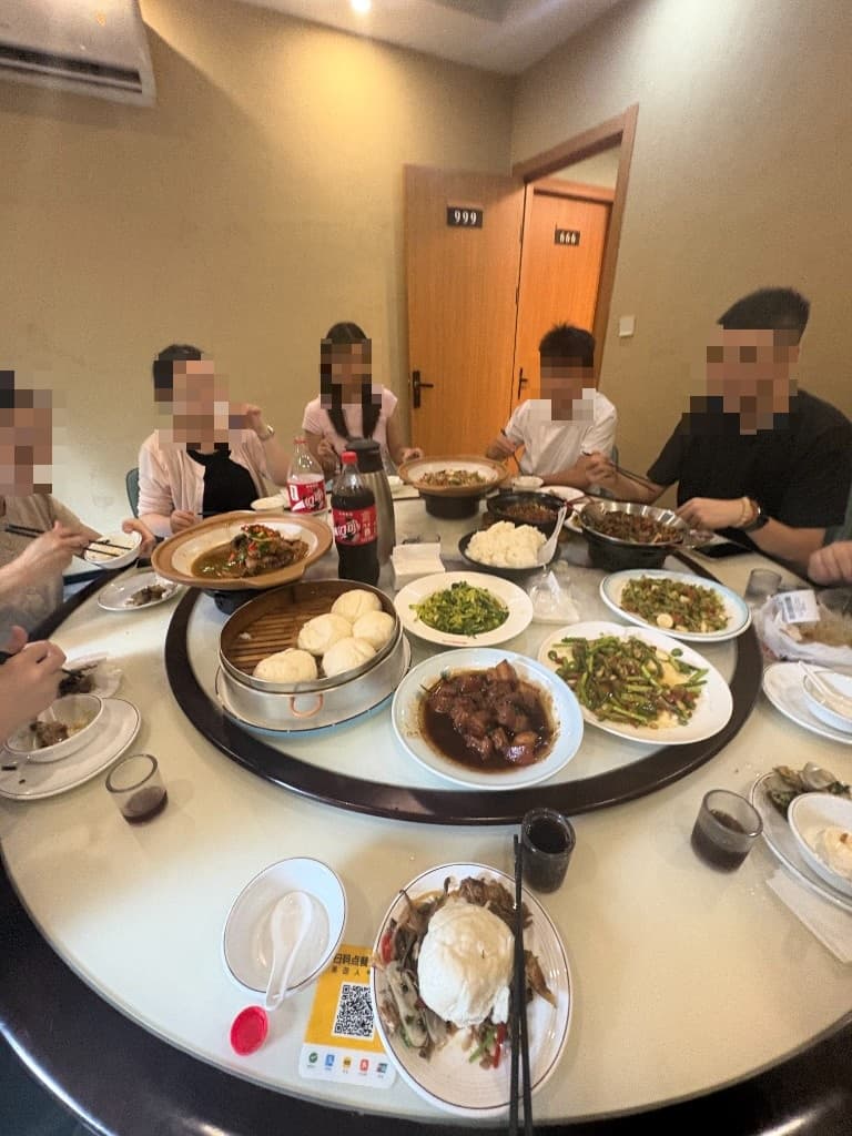 The team sharing lunch around a round table, faces pixelated